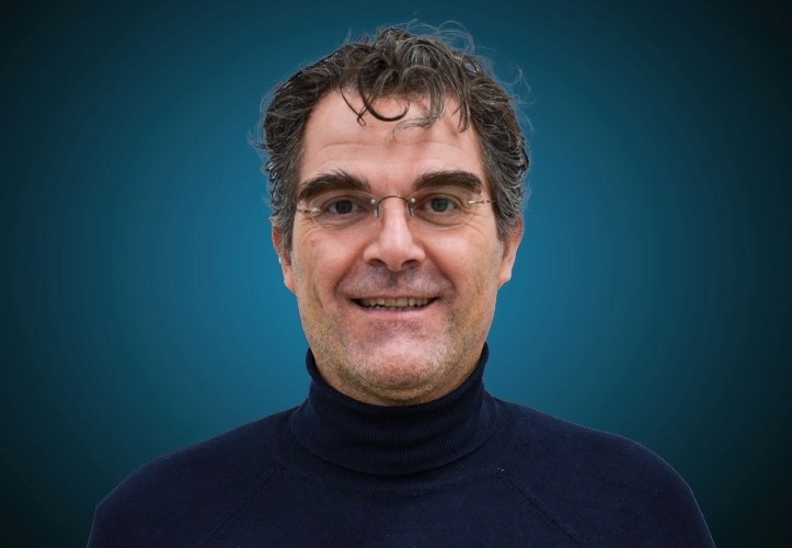 Portraitfoto eines Fachberaters für Hochbau im Außendienst von CAPITAL Baustoffe vor einem blauem Hintergrund