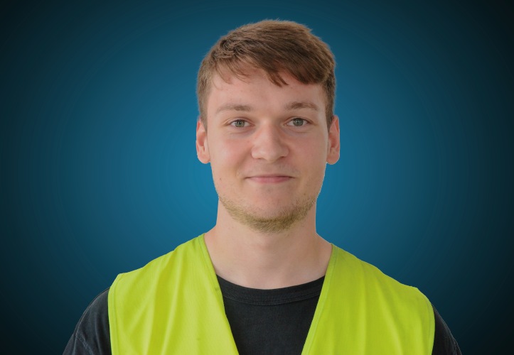 Portraitfoto eines Lagermitarbeiters von CAPITAL Baustoffe vor einem blauem Hintergrund