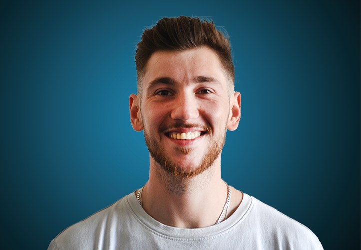 Portraitfoto eines Verkäufers von CAPITAL Baustoffe vor einem blauem Hintergrund