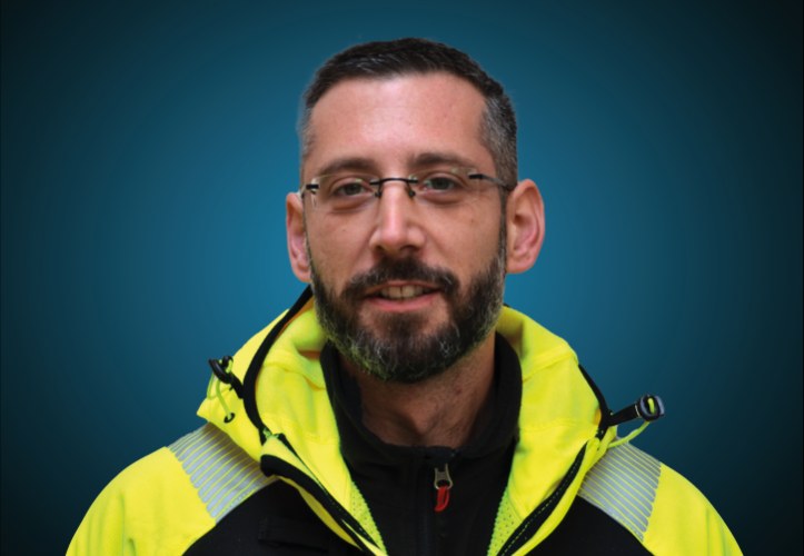 Portraitfoto eines Lagermitarbeiters von CAPITAL Baustoffe vor einem blauem Hintergrund