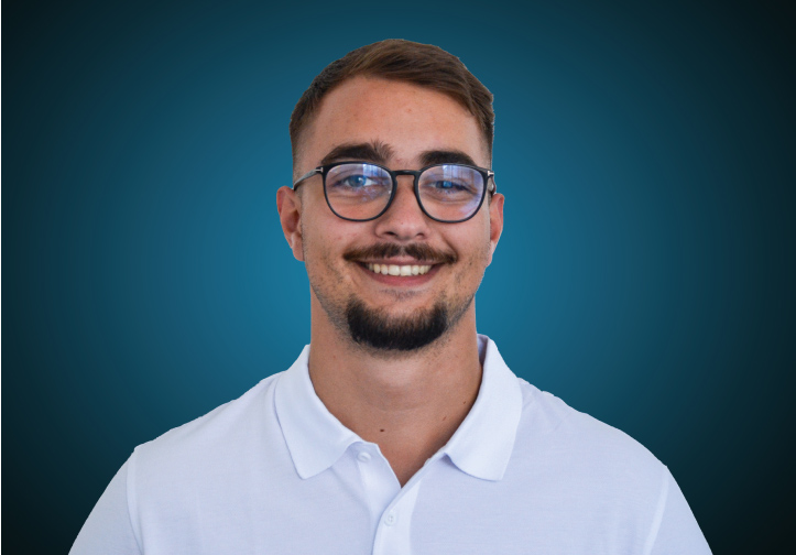 Portraitfoto eines Fachberaters für Bauelemente im Innendienst von CAPITAL Baustoffe vor einem dunkelblauen Hintergrund
