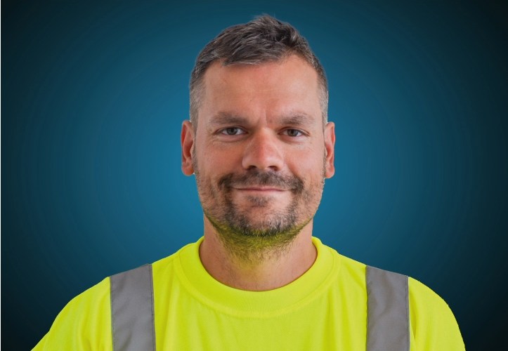 Portraitfoto eines Fahrers von CAPITAL Baustoffe vor einem blauem Hintergrund