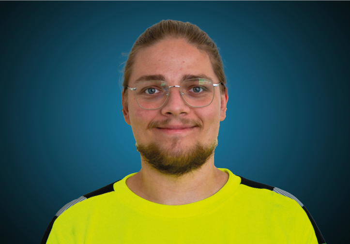 Portraitfoto eines Lagermitarbeiters von CAPITAL Baustoffe vor einem blauem Hintergrund