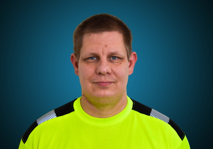 Portraitfoto eines Lagermitarbeiters von CAPITAL Baustoffe vor einem blauem Hintergrund