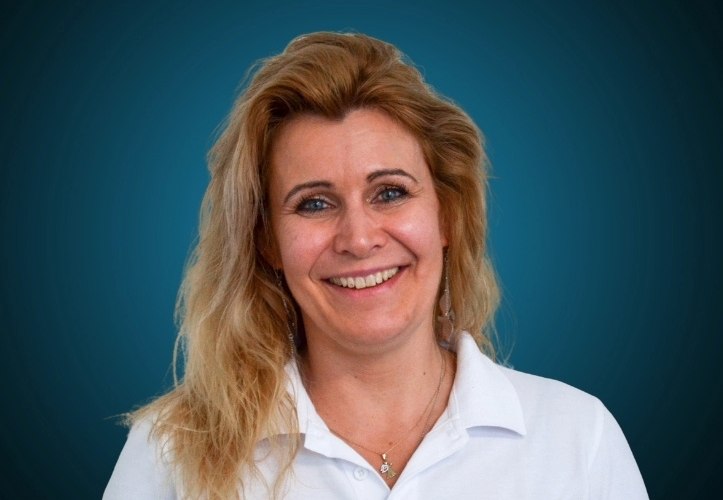 Portraitfoto eines Fachberaters für Bauelemente im Innendienst von CAPITAL Baustoffe vor einem dunkelblauen Hintergrund