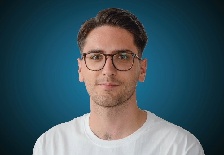 Portraitfoto eines Fachberaters für Estrich im Innendienst von CAPITAL Baustoffe vor einem blauem Hintergrund