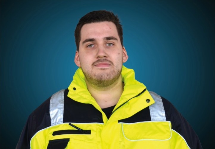 Portraitfoto eines Lagermitarbeiters von CAPITAL Baustoffe vor einem blauem Hintergrund