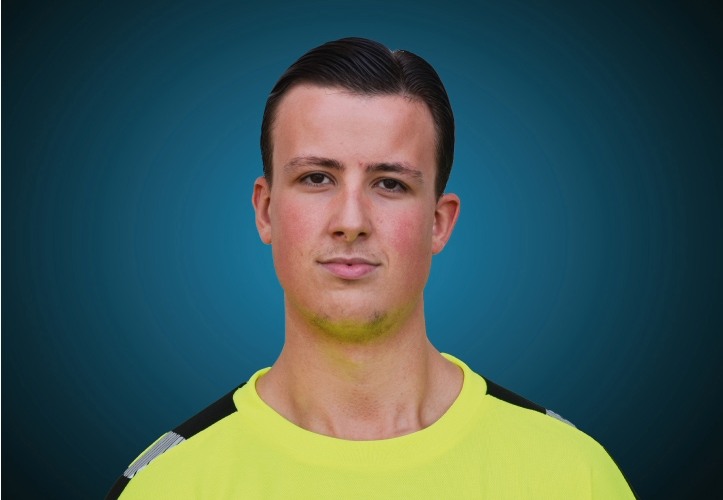 Portraitfoto eines Auszubildenen von CAPITAL Baustoffe vor einem blauem Hintergrund