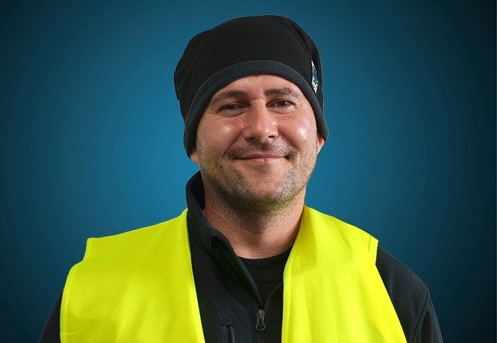 Portraitfoto eines Fahrers von CAPITAL Baustoffe vor einem blauem Hintergrund
