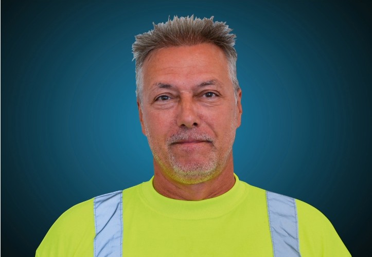 Portraitfoto eines Fahrers von CAPITAL Baustoffe vor einem blauem Hintergrund