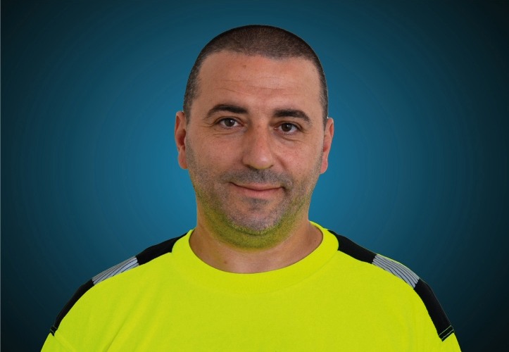 Portraitfoto eines Lagermitarbeiters von CAPITAL Baustoffe vor einem blauem Hintergrund