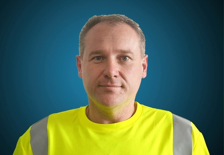 Portraitfoto eines Fahrers von CAPITAL Baustoffe vor einem blauem Hintergrund