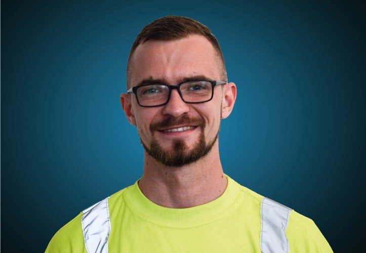 Portraitfoto eines Lagermitarbeiters von CAPITAL Baustoffe vor einem blauem Hintergrund