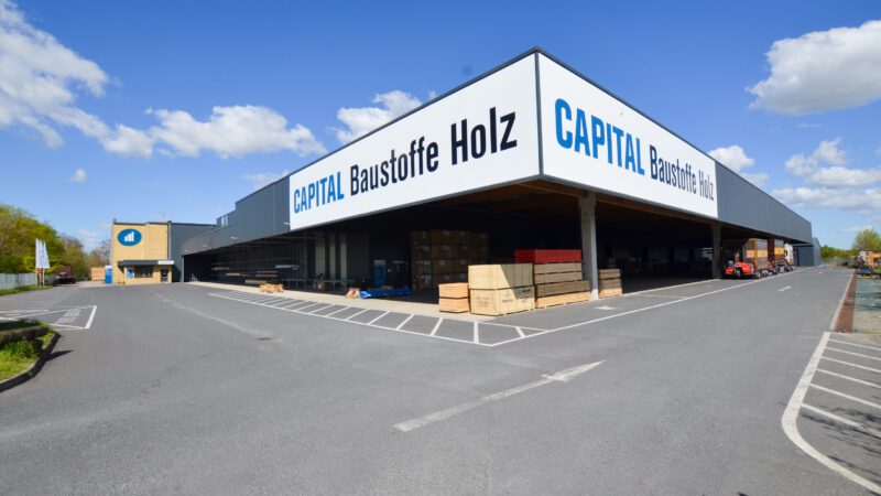 Außenansicht des CAPITAL Baustoffe Holz Standorts Dallgow-Döberitz mit überdachtem Holzlager
