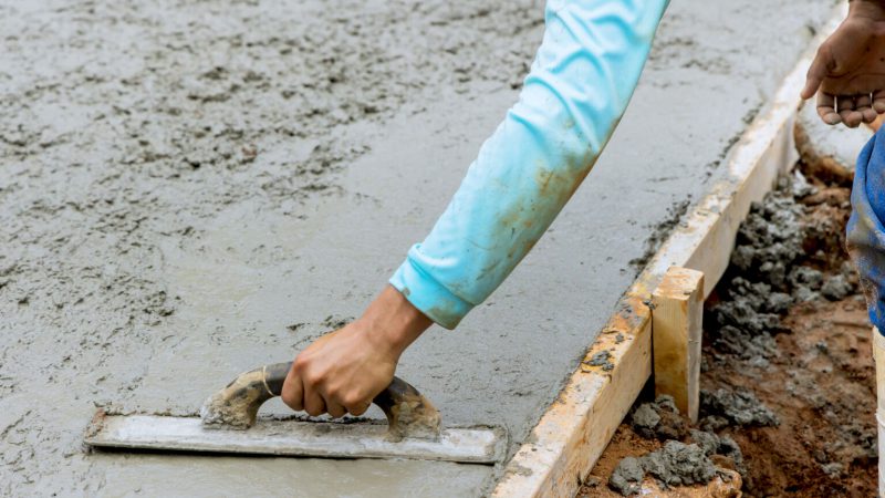 Bauarbeiter streich Estrich mit Kelle glatt